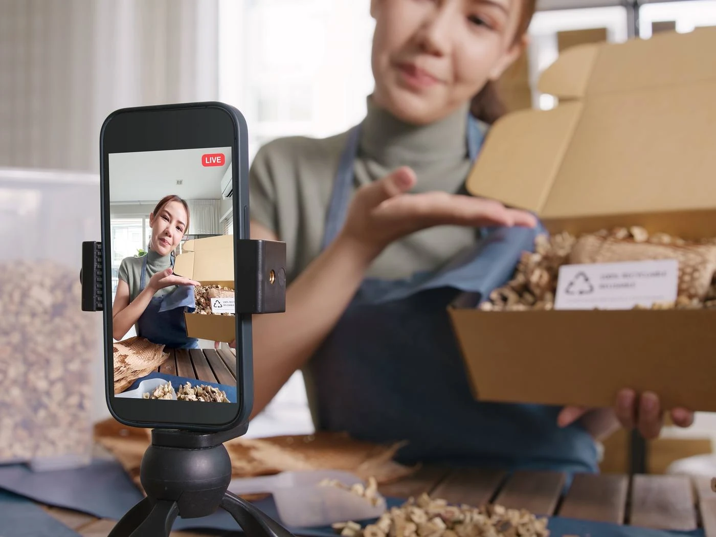 Mitarbeiterin filmt mit dem Smartphone einen Beitrag aus dem Arbeitsalltag